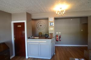 a living room with a counter and a clock on the wall at Achilty Guest House in Contin