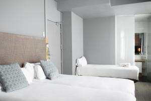 Łóżko lub łóżka w pokoju w obiekcie Petit Palace Alcalá