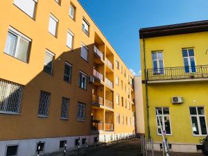 a yellow building next to another yellow building at Ella Apartman in Debrecen