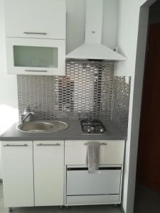 a white kitchen with a sink and a stove at Iwona in Świnoujście