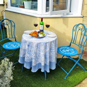 a table with a plate of food and two glasses of wine at Southgrove View, Family Holiday Cottage in Ventnor
