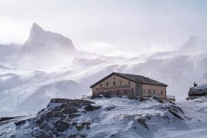 a building on the top of a snowy mountain at Hotel Schwarzsee in Zermatt