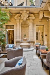 a lobby with chairs and a fountain in a building at 66 Saint Paul's & Spa in Valletta