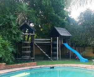 a swimming pool with a pool table and chairs at 33rd on Carlton in Johannesburg