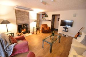 sala de estar con sofá y chimenea en Achilty Guest House, en Contin