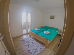 een kleine slaapkamer met een groen bed in een kamer bij Prenočišča Rusjan in Renče
