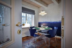 a dining room with a table and blue chairs at Ferienhaus Lochterbarig in Munkmarsch