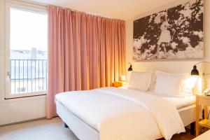 a bedroom with a bed and a large window at Hotel Rival in Stockholm