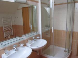 ein Badezimmer mit zwei Waschbecken und einer Glasdusche in der Unterkunft Obora 827 Nova Bystrice in Nová Bystřice