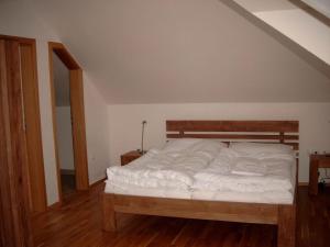 1 dormitorio con 1 cama grande con sábanas blancas en Obora 827 Nova Bystrice, en Nová Bystřice