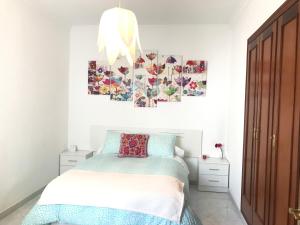 una camera da letto con un letto e due quadri sul muro di Apartamento Conocedores a Jerez de la Frontera