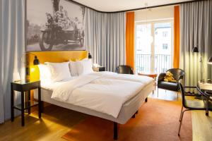 a bedroom with a large white bed and a desk at Hotel Rival in Stockholm