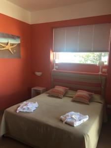 a bedroom with two beds with red walls and a window at SUITEBEACH b&b and resort in Marsala