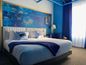a blue bedroom with a large bed with an eyeballsigunigunigun at Angad Arts Hotel in Saint Louis