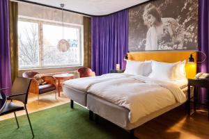 a bedroom with a large bed and purple curtains at Hotel Rival in Stockholm