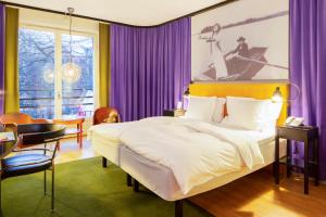 a bedroom with a large bed and purple curtains at Hotel Rival in Stockholm