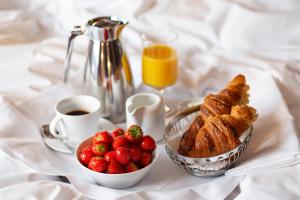 a table with a breakfast of croissants strawberries and coffee at Hotel Rival in Stockholm