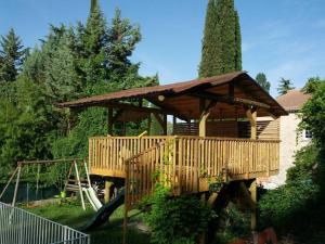 a wooden gazebo with a playground in a yard at Villa du Lez in Prades-le-Lez