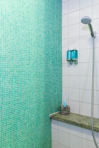 a bathroom with a green tiled shower with a shower head at Hotel Rival in Stockholm