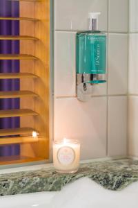 a candle on a counter next to a bottle of soap at Hotel Rival in Stockholm