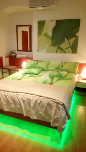 a bedroom with a bed with green lights on it at Vila Zlata in Punat