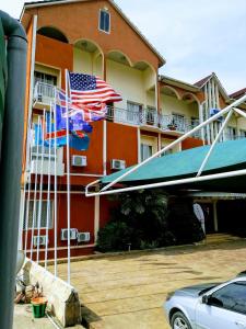 a building with american flags in a parking lot at Hotel Vivi Palace in Matadi