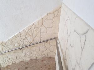 una escalera con una pared de piedra y una barandilla en Dill Hotel en Ilsede