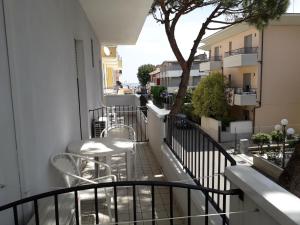 a balcony with tables and chairs on a building at Hotel Lora in Rimini
