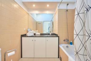 uma casa de banho com um lavatório, uma banheira e um chuveiro em Salgadeiras Suites - Bairro Alto em Lisboa