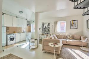 uma sala de estar com um sofá e uma cozinha em Salgadeiras Suites - Bairro Alto em Lisboa