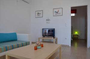 KamáriaにあるHelona Housesのソファとテーブルとテレビのあるリビングルーム