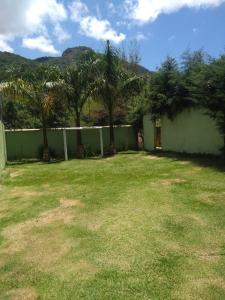 a yard with a fence and palm trees at Recanto dos Sonhos in Vargem