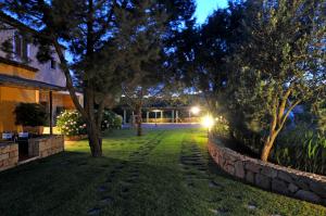 a garden at night with trees and a building at Hotel Il Piccolo Golf in Porto Cervo