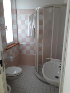 a bathroom with a shower and a toilet and a sink at Hotel Lora in Rimini
