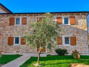 a building with a tree in front of it at Bed & Breakfast Kaštel in Žbandaj