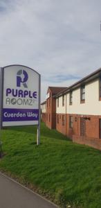 una señal para una habitación púrpura frente a un edificio en Purple Roomz Preston South, en Preston