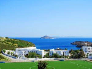 uma vista para um campo de ténis e para o oceano em Porto Scoutari Romantic Hotel em Skala