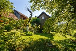un jardín con una casa de madera en el fondo en Osmak in Gusti Laz (Haus für 4 Personen), en Brod na Kupi