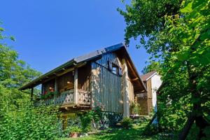 une cabane en bois avec un balcon dans une maison dans l'établissement Osmak in Gusti Laz (Haus für 4 Personen), à Brod na Kupi