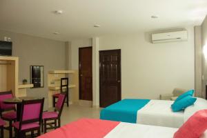 a hotel room with two beds and a table and chairs at HOTEL DE LA PEÑA INN in Santo Domingo Tehuantepec