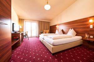 una camera d'albergo con due letti e una televisione di Hotel Landskron a Bruck an der Mur
