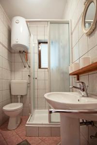 a bathroom with a sink and a toilet and a shower at Apartments Petrčane Welcome in Petrcane +67 photos