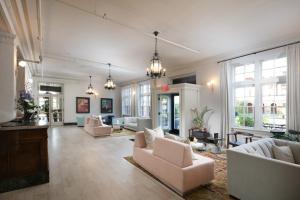 a large living room with white furniture and windows at Hotel Weyanoke in Farmville