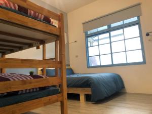 a bedroom with two bunk beds and a window at 巷弄內的老宅 in Pingtung City