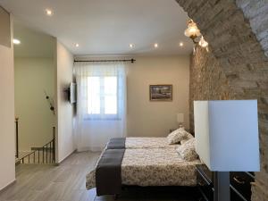 1 dormitorio con cama y pared de piedra en Casa de piedra adaptada en LEscala, en L'Escala