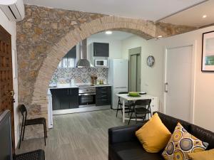 uma sala de estar com um sofá e uma cozinha em Casa de piedra adaptada en LEscala em L'Escala