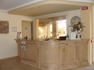 a reception counter with a clock on the wall at Hotel Belforte in Ovada