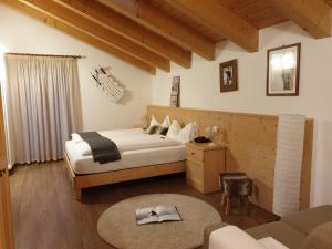 a bedroom with a bed and a couch in a room at Hotel Chalet Giasenei in Sagron Mis