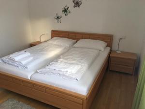 un letto con lenzuola e cuscini bianchi di Sonnenalpe Apartments Nassfeld a Sonnenalpe Nassfeld