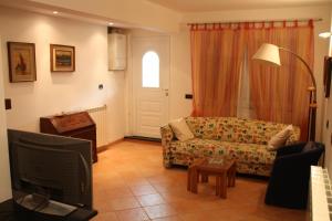 een woonkamer met een bank en een tv bij Casa Elena in Moneglia